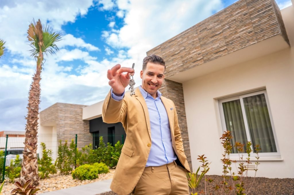 Real state agent showing keys of a new house